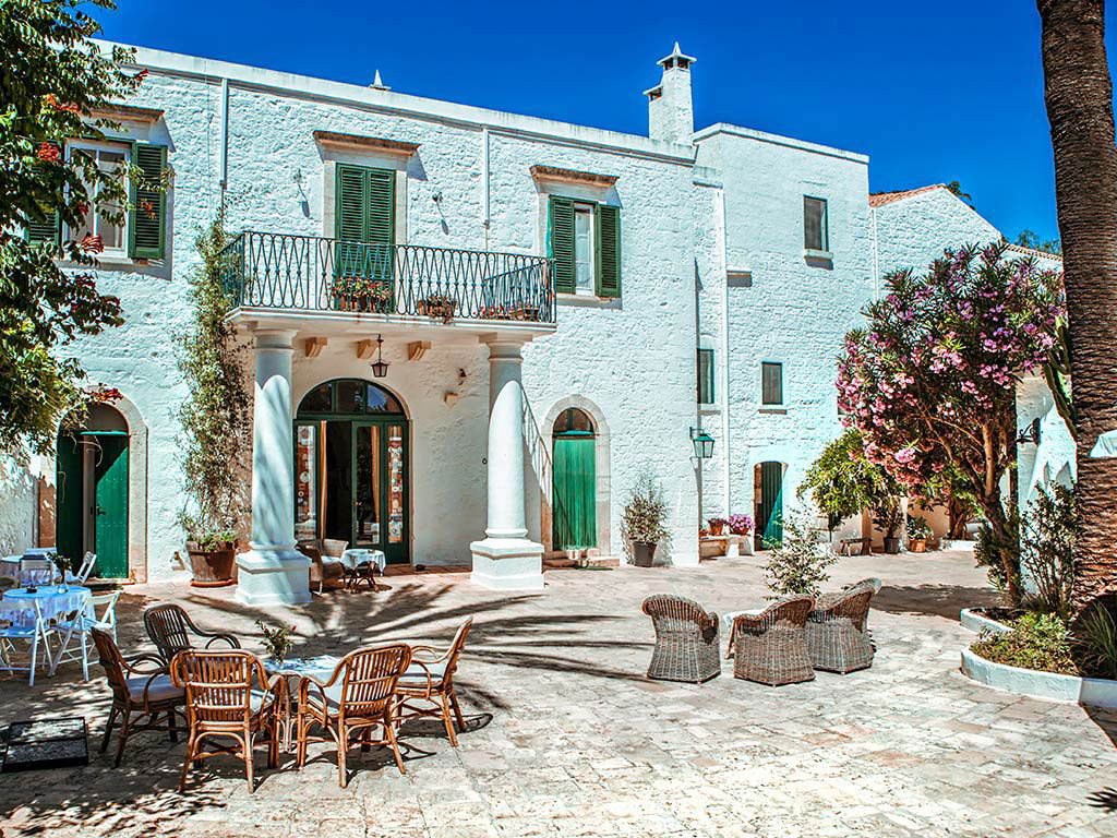 Masseria di Charme Itria a Ostuni con corte in pietra e edificio storico tra ulivi