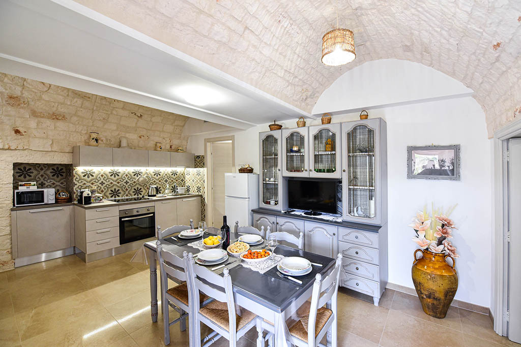 Soggiorno con cucina Soggiorno con camino del Trullo Autentico Puglia arredato in stile tradizionale